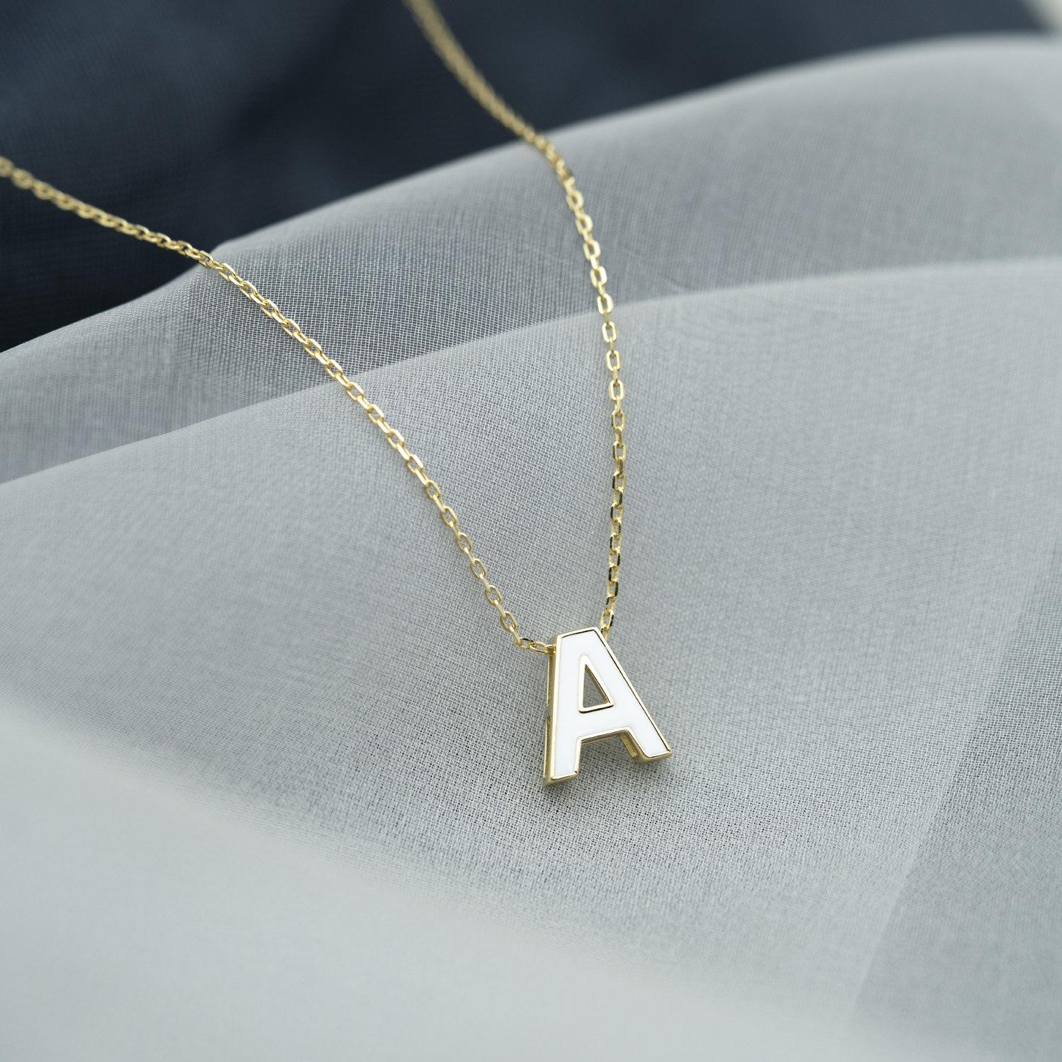 Bilde nummer 2 av Pan Jewelry, Bokstavsmykke i forgylt 925 sølv med hvit emalje